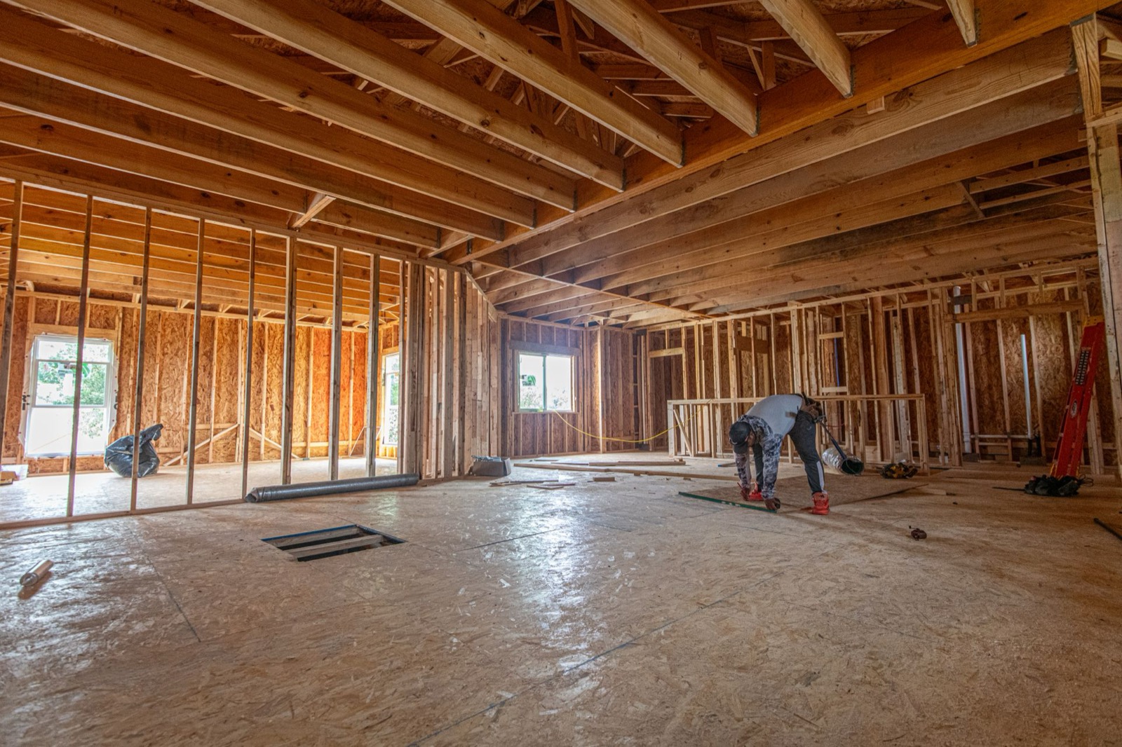 Interior framing stage of a new home, with wood offcuts and job-site debris on the subfloor